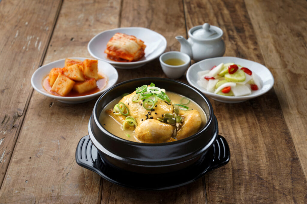 Traditional samgyetang with whole chicken, ginseng, rice, and Korean side dishes in Seoul